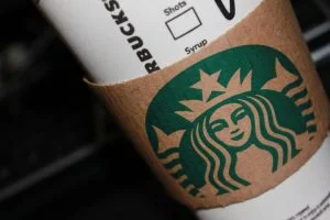 Starbucks-Getränkebecher mit brauner Papphülle und grünem Logo.
