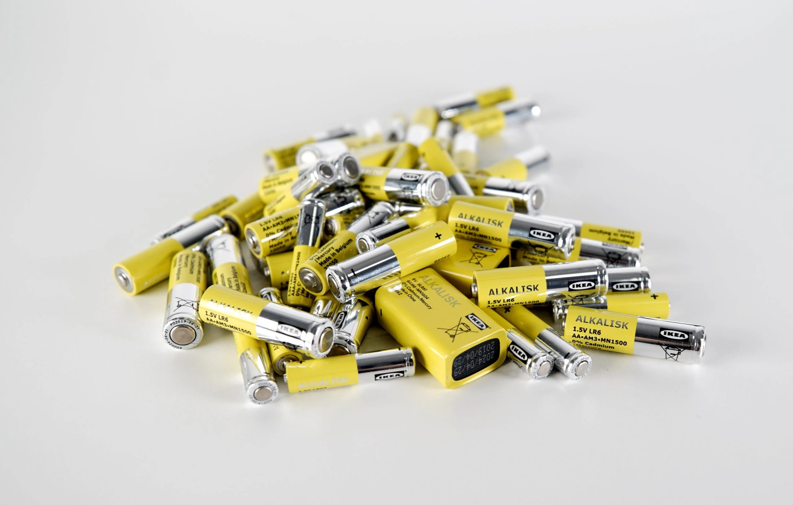 Pilha de pilhas alcalinas IKEA ALKALISK AA 1,5V espalhadas sobre fundo branco