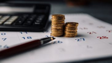 Calendar,,Calculator,And,Stack,Of,Coins,In,A,Office