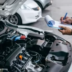 Mechanic check list to the clipboard insurance with inspecting car at garage workshop, Car auto services and maintenance check concept.