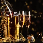 Happy New Year! A golden bucket with champagne, two glasses and a golden serpentine against the background of a clock face.