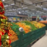 Christmas tree detail with supermarket fruit sector blurred background. selective focus.