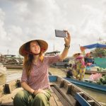Woman tourist take selfie photo from the boat on Cai Rang floating market, Can Tho, Vietnam