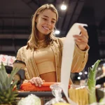 Young happy customer woman wears casual clothes read check bill shopping at supermaket store grocery shop buying with trolley cart choose products in hypermarket. Purchasing food gastronomy concept