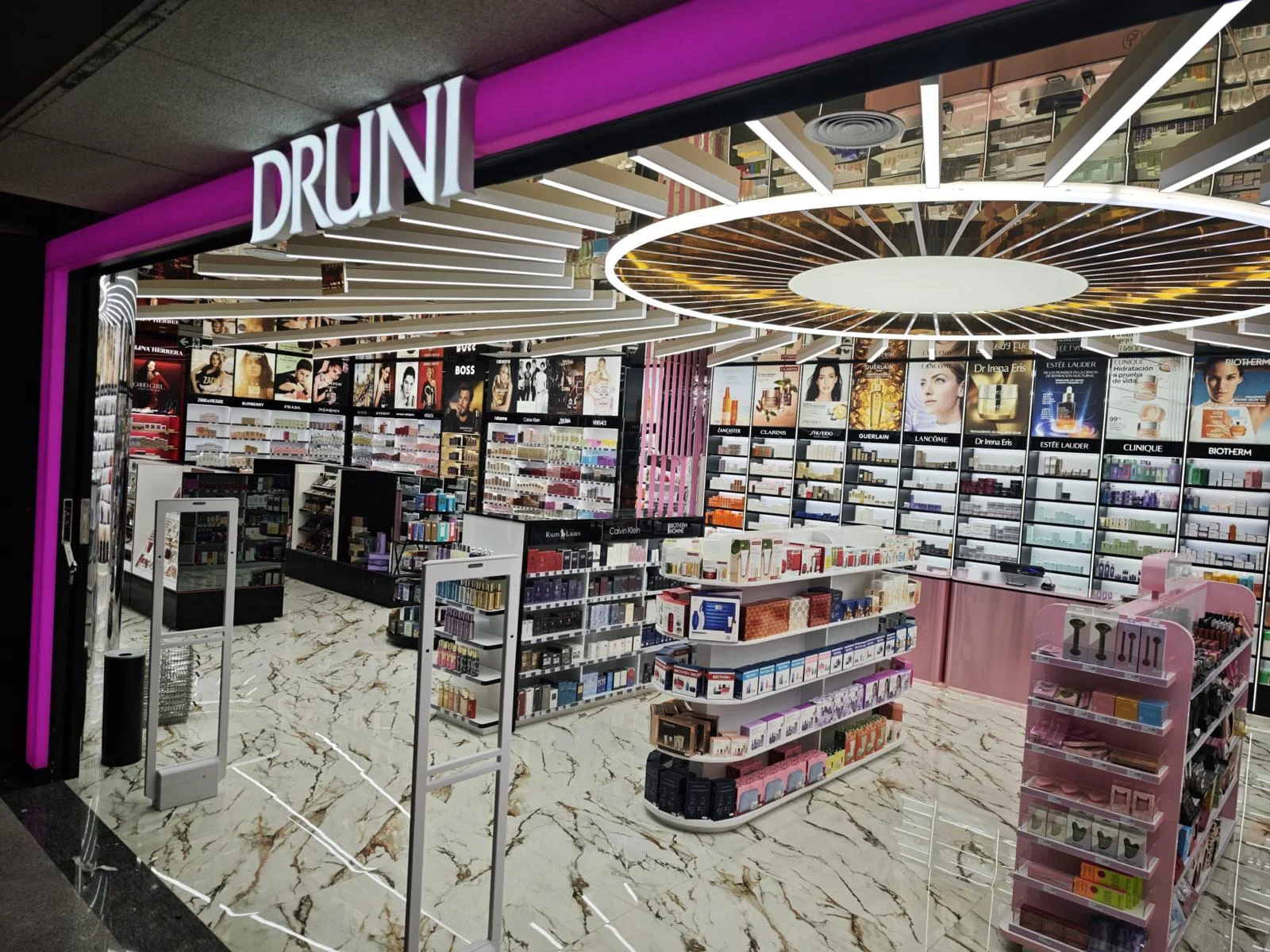 Interior de uma loja Druni, com prateleiras repletas de perfumes, cosméticos e produtos de beleza