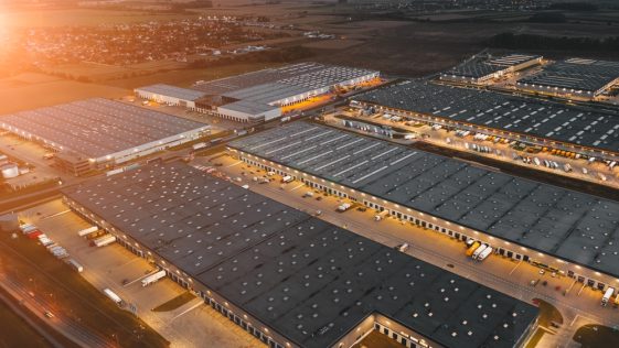 Night aerial view of a warehouse of goods for online stores. Logistic center in the industrial area of the city from above.