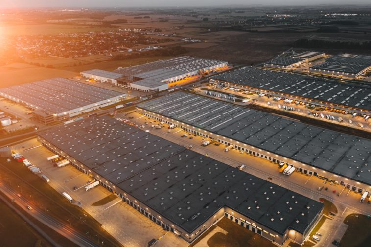 Night aerial view of a warehouse of goods for online stores. Logistic center in the industrial area of the city from above.