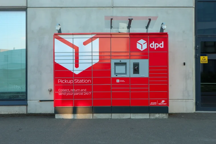 Tallinn - 20 de julho de 2025. Máquina de armário de encomendas DPD vermelho, uma estação de coleta em frente a um edifício de escritórios, em uma calçada em Tallinn.