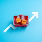 Um carrinho de compras com mercadorias in a box e uma seta apontando para cima. Maior consumo. Preços altos, inflação crescente. Tendências do comportamento de compra. Custo de vida e análise de mercado.
