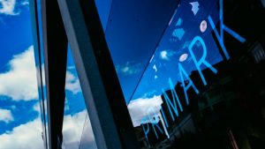 Fachada envidraçada de uma loja Primark, com o nome da marca visível
