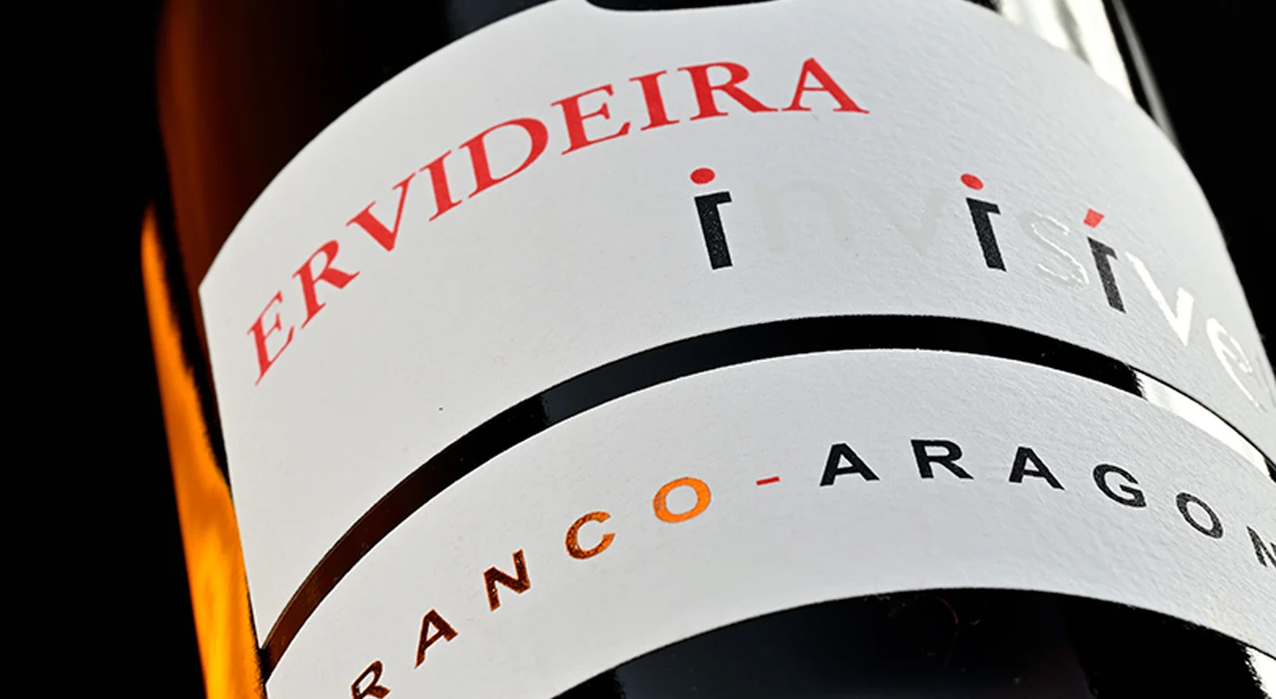 Rótulo de garrafa de vinho “Ervideira Invisível”, com destaque para a designação branco–aragonez e design minimalista