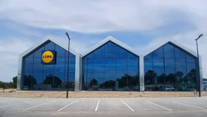 Supermercado Lidl com fachada envidraçada e parque de estacionamento vazio