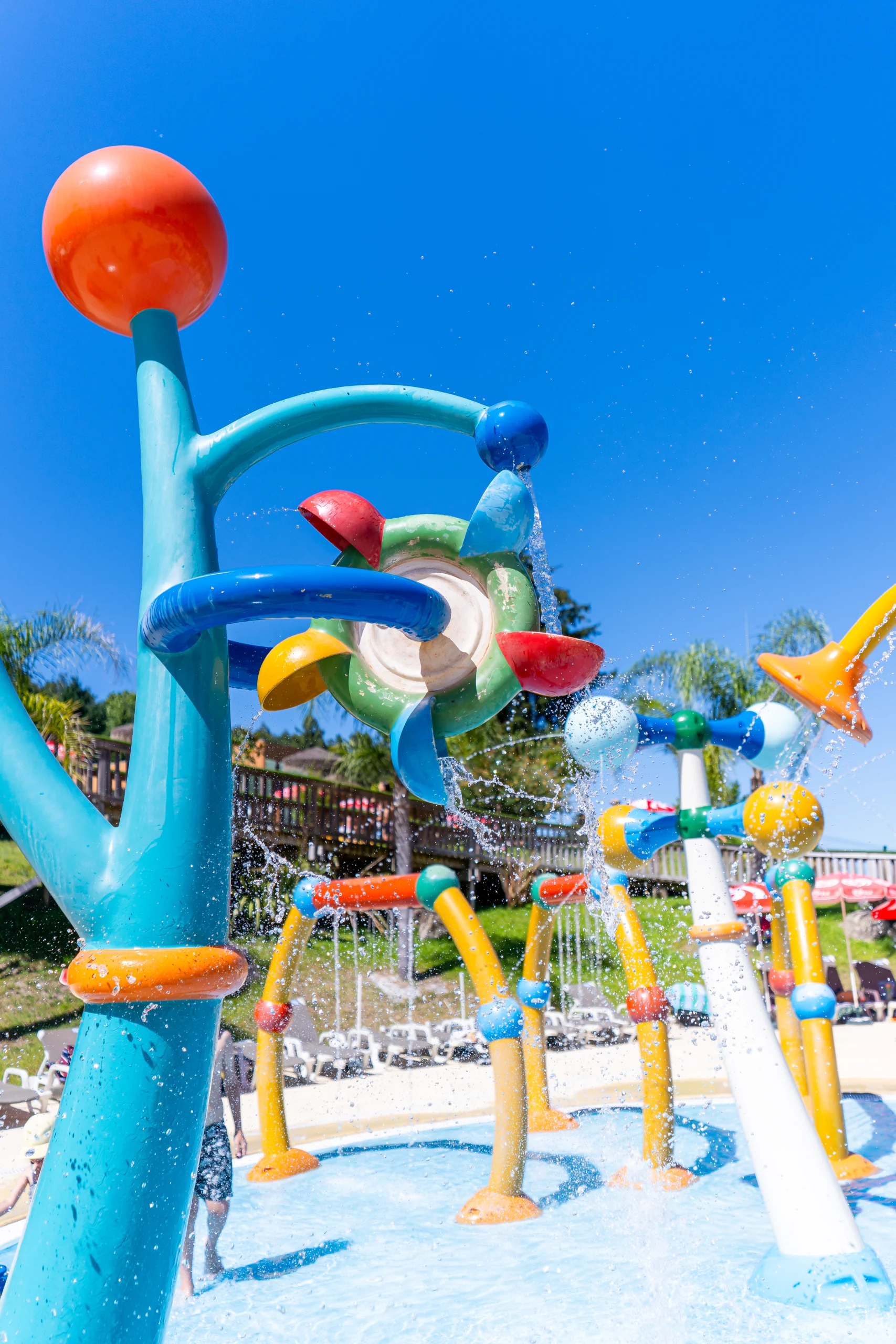 Estrutura de jogos aquáticos colorida com jatos de água num parque aquático ao ar livre