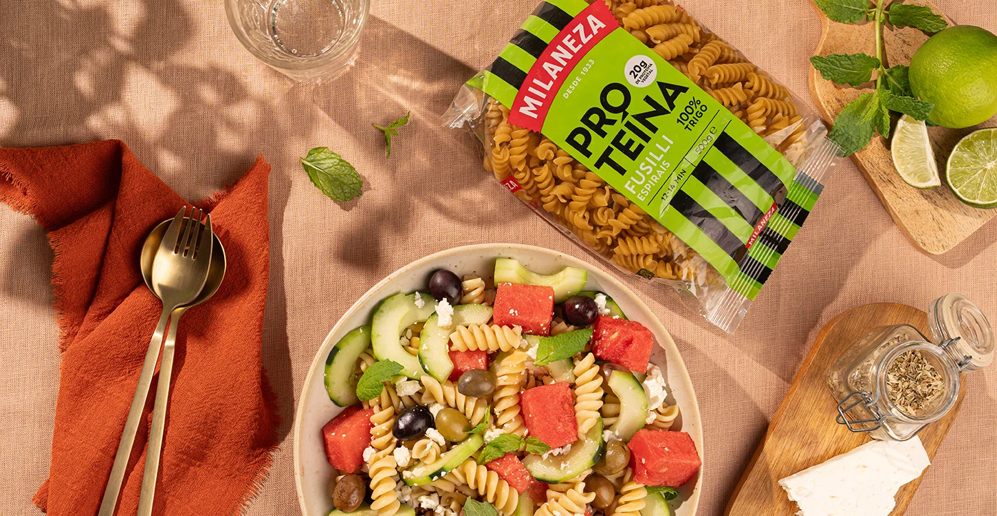 Salada de fusilli com melancia, pepino, azeitonas e queijo feta, junto à embalagem Milaneza Proteína