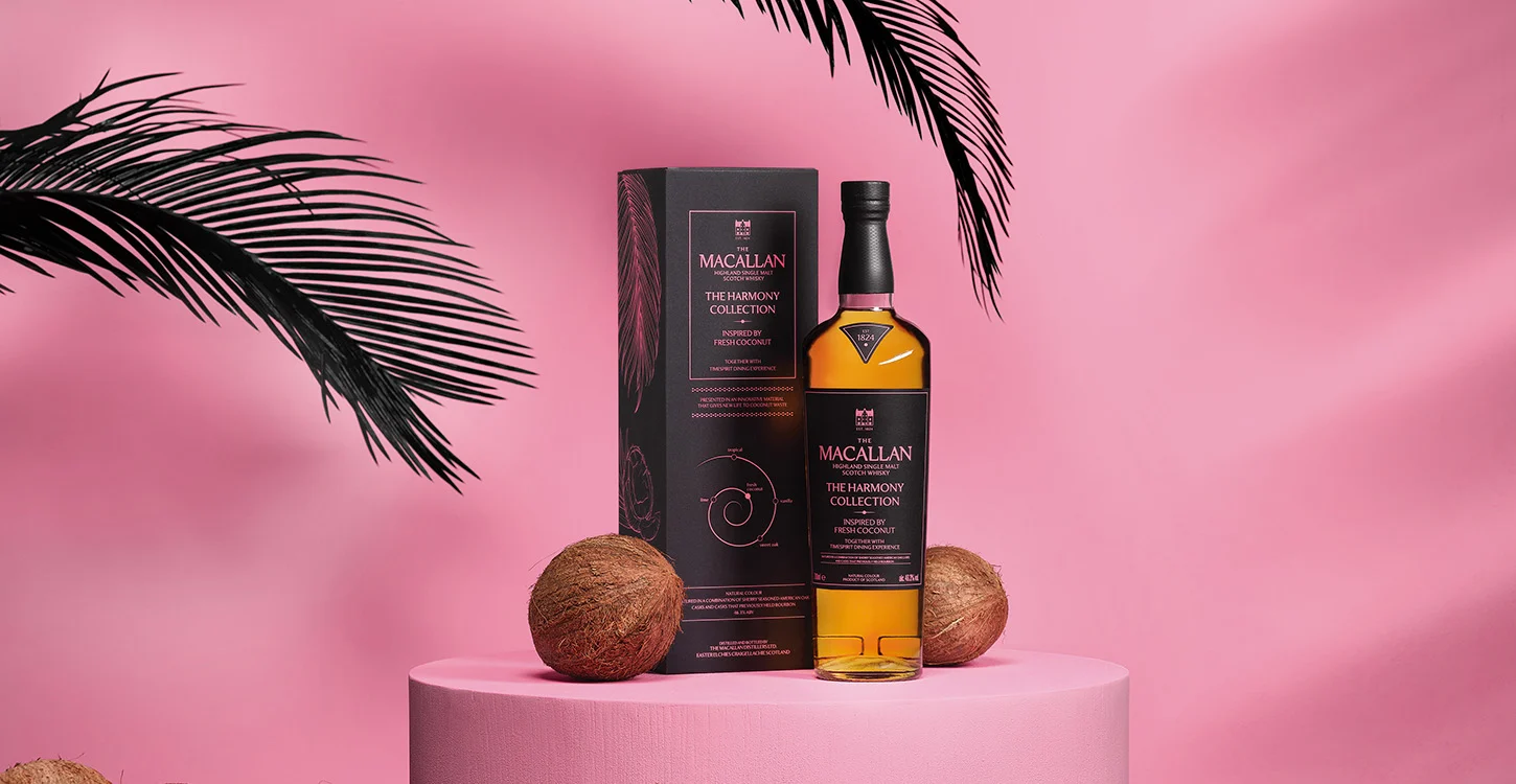 Garrafa e embalagem do whisky The Macallan Harmony Collection, inspirado em coco fresco, sobre um pedestal cor-de-rosa