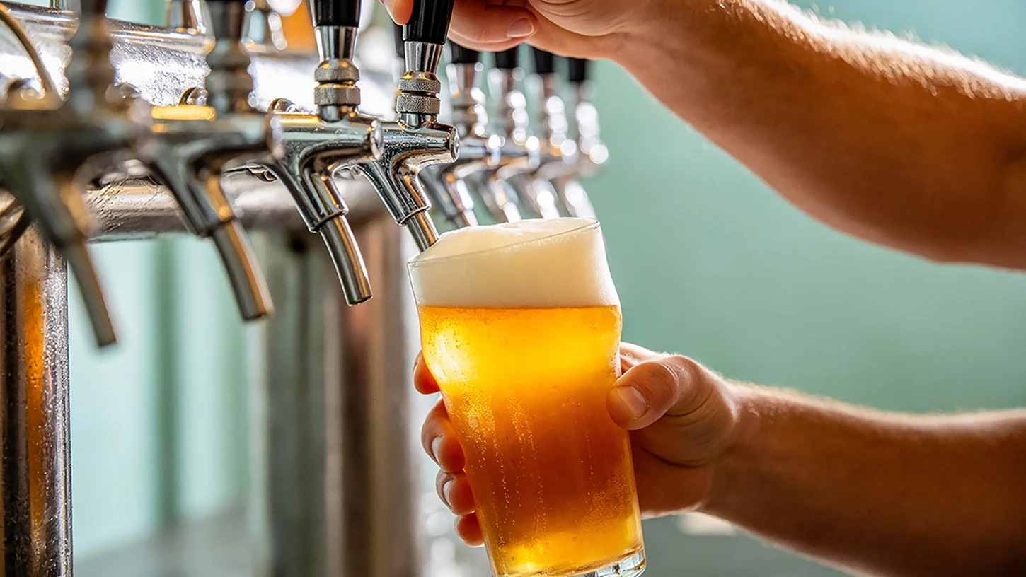 Copo de cerveja a ser enchido numa torneira de cerveja