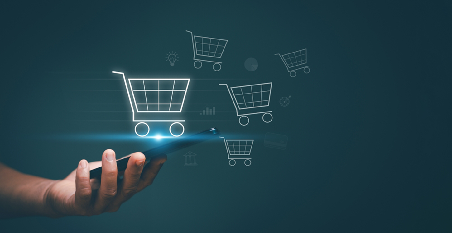 Mão a segurar um smartphone com ícones de carrinhos de compras digitais