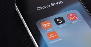 Ecrã de smartphone com a pasta “China Shop” e aplicações Temu, SHEIN e AliExpress