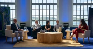 Cinco pessoas sentadas numa sala luminosa, aparentemente num painel de conversa