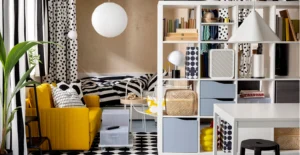 Interior de uma divisão colorida, com poltrão amarelo, cama, estante branca e decoração a preto e branco