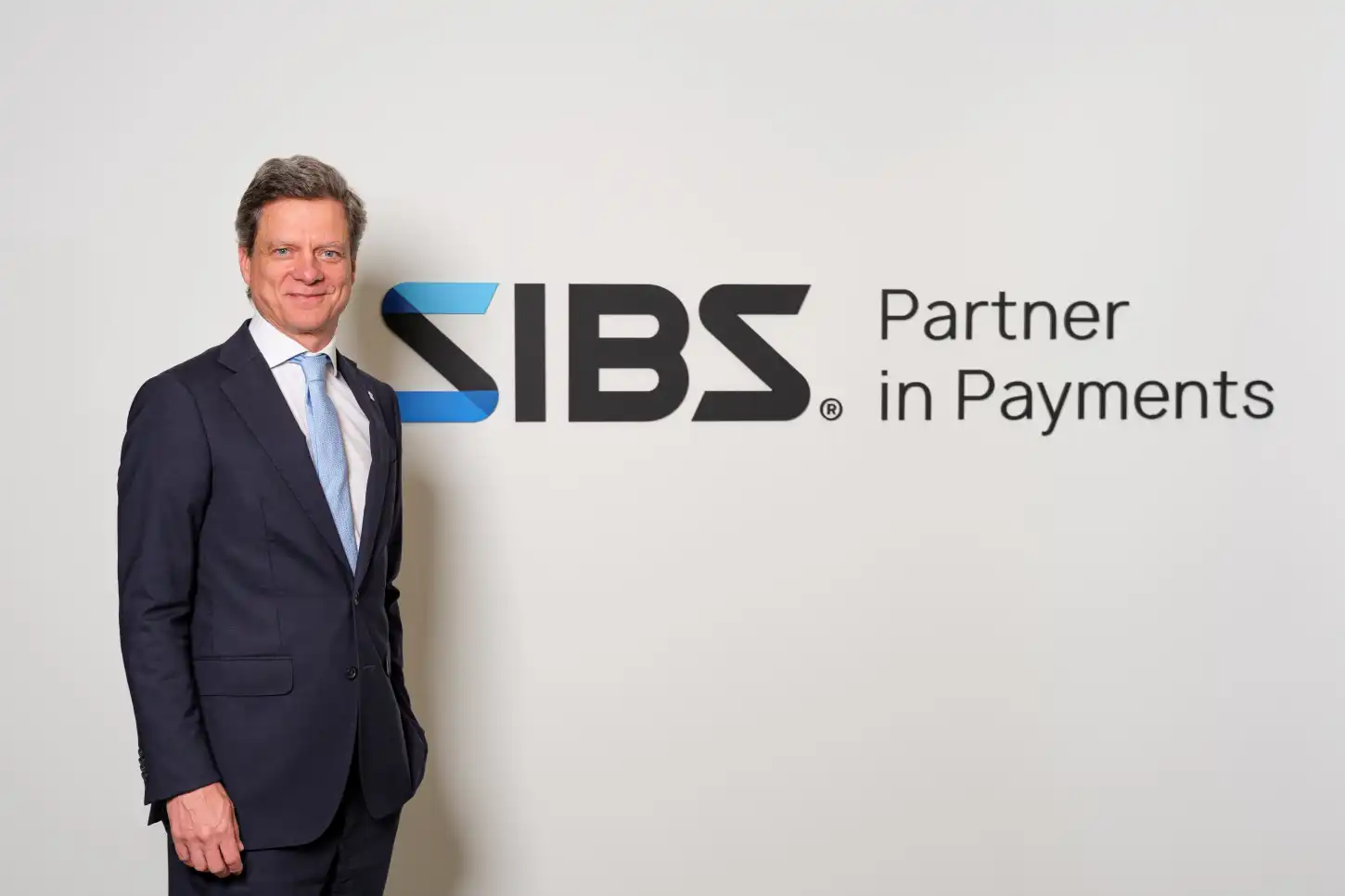 Homem de fato junto ao logótipo SBS e à frase «Partner in Payments»