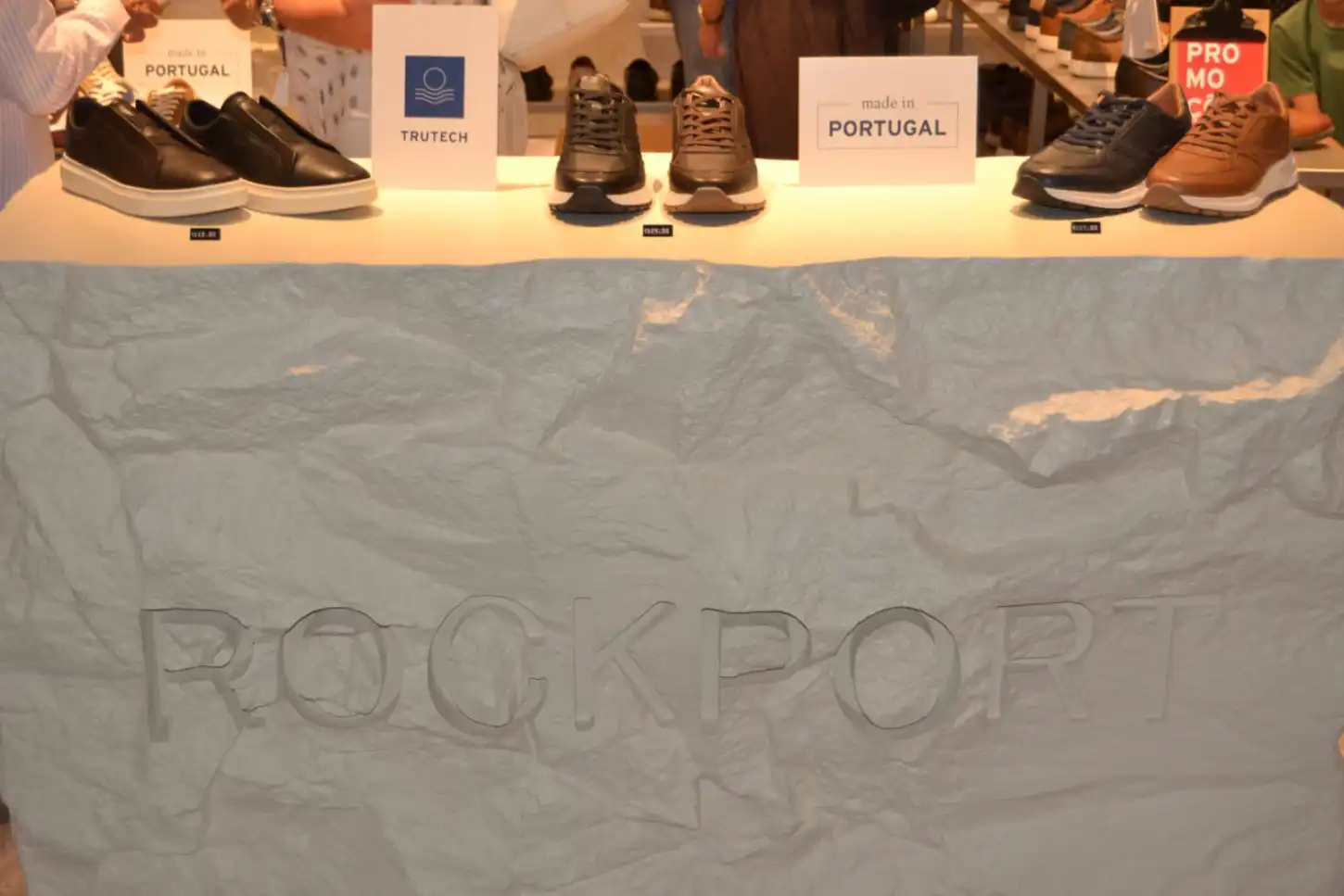 Expositor de calçado Rockport, com vários modelos e cartazes “made in PORTUGAL” e “TRUTECH”