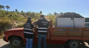 Dois agentes da ASAE inspecionam uma carrinha de caixa aberta