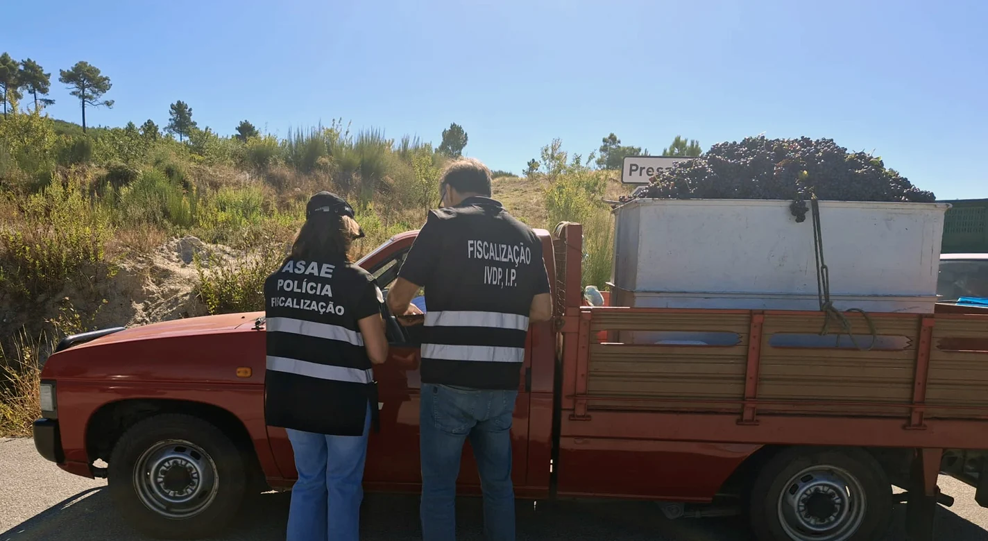 Dois agentes da ASAE inspecionam uma carrinha de caixa aberta