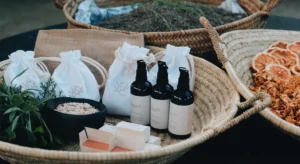 Produtos de cosmética artesanal, ervas, sais e rodelas de citrinos secos dispostos em cestos de vime
