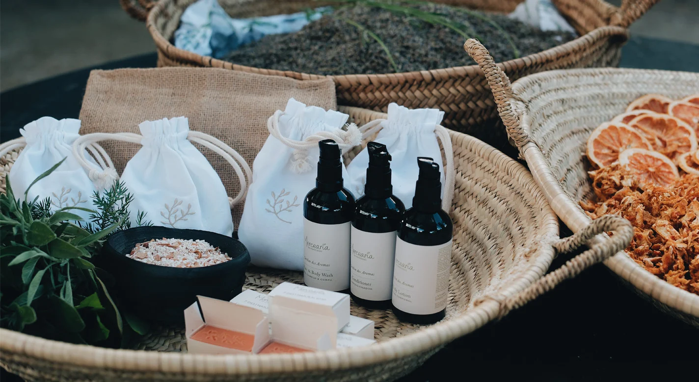Produtos de cosmética artesanal, ervas, sais e rodelas de citrinos secos dispostos em cestos de vime