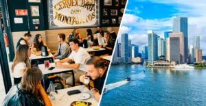 Clientes num restaurante e skyline de arranha-céus junto à água, com barcos no primeiro plano