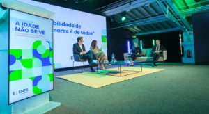 Painel da conferência «A idade não se vê», com quatro participantes sentados num palco