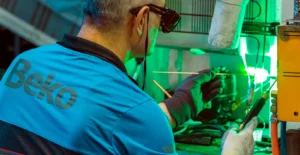 Técnico com equipamento de protecção ajusta maquinaria industrial