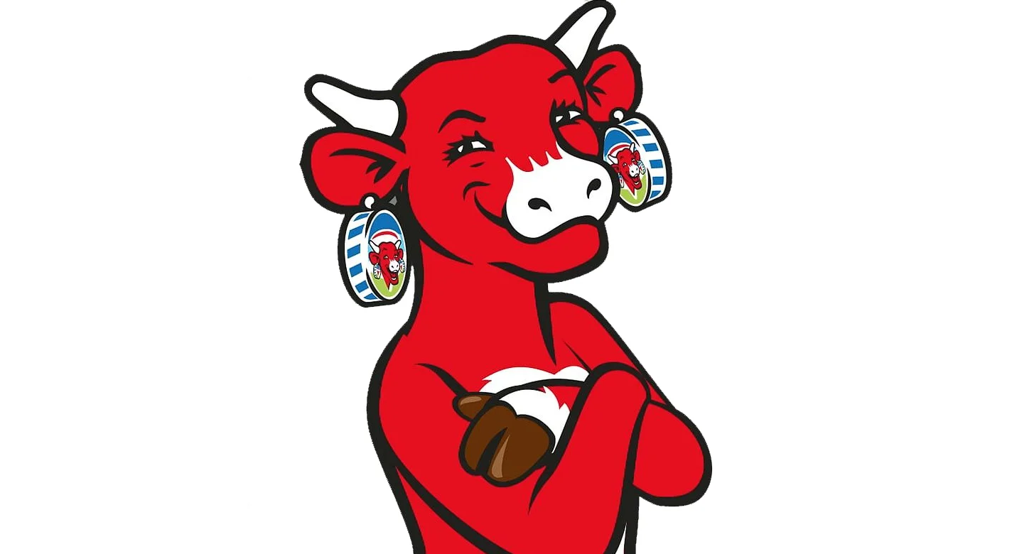 Mascote de touro vermelho sorridente, com brincos em forma de latas e a segurar uma bola de futebol