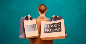 Mulher de costas segura vários sacos de compras com a inscrição «BLACK FRIDAY»
