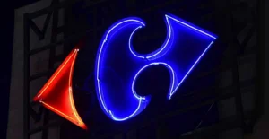 Logótipo iluminado a néon, com um símbolo azul e um triângulo vermelho