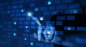 Mão a tocar num ecrã digital com vários ícones de cadeados, representando segurança informática