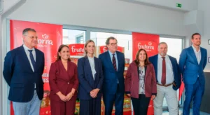 Sete pessoas posam junto a expositores de produtos Frutorra