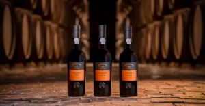 Três garrafas de vinho do Porto Ferreira Colheita, das colheitas de 2001, 2006 e 2008, numa adega