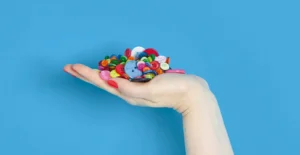 Mão aberta a segurar uma coleção colorida de botões sobre um fundo azul