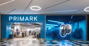 Entrada de uma loja Primark num centro comercial, com montras iluminadas e manequins
