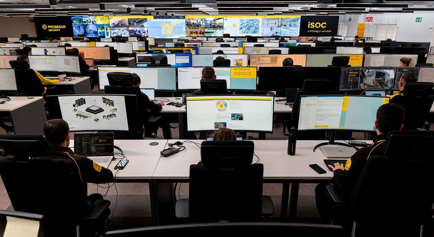Centro de operações de segurança com vários profissionais a monitorizar dezenas de ecrãs
