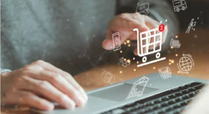 Pessoa a utilizar um computador portátil, com ícones de compras online sobrepostos