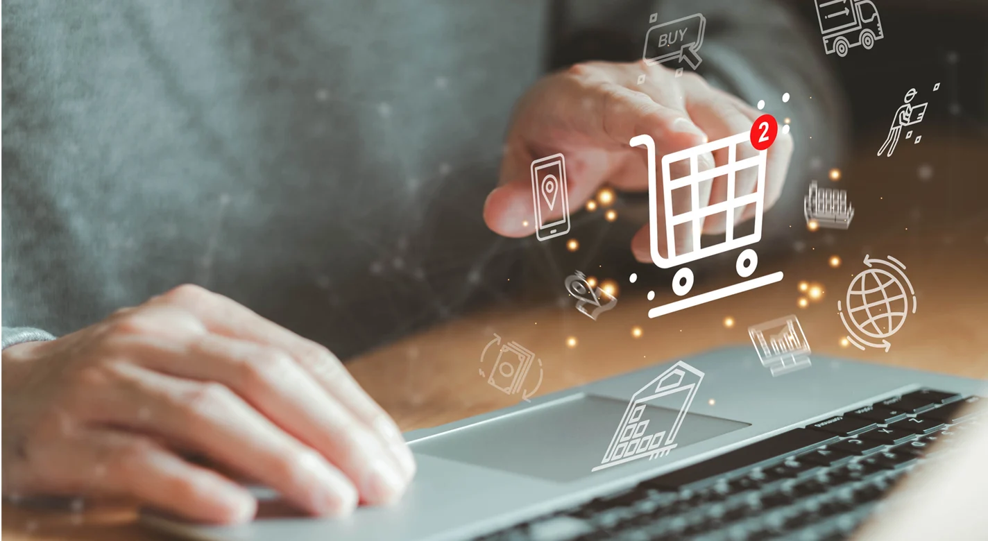 Pessoa a utilizar um computador portátil, com ícones de compras online sobrepostos