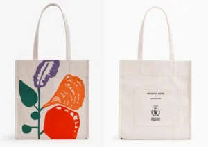 Saco de compras de lona branca com ilustração floral colorida; no verso, texto Michael Kors e World Food Programme